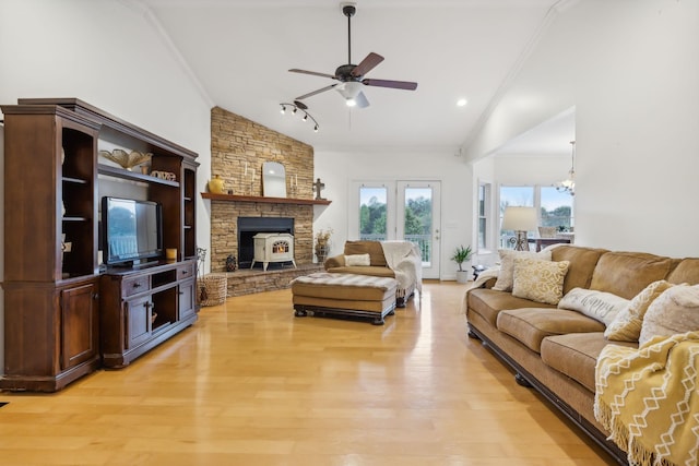 living room with crown molding, ceiling fan with notable chandelier, light hardwood / wood-style flooring, and vaulted ceiling