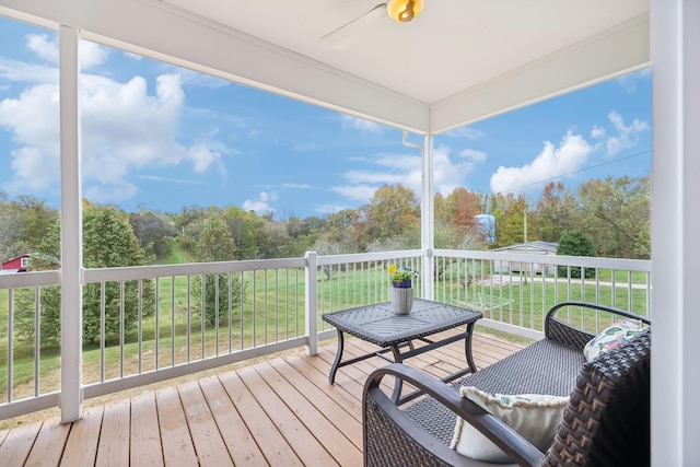 deck featuring ceiling fan and a lawn