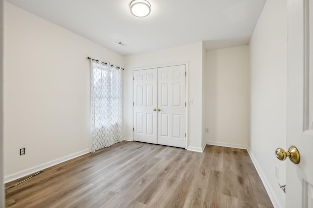 unfurnished bedroom with a closet and light hardwood / wood-style flooring