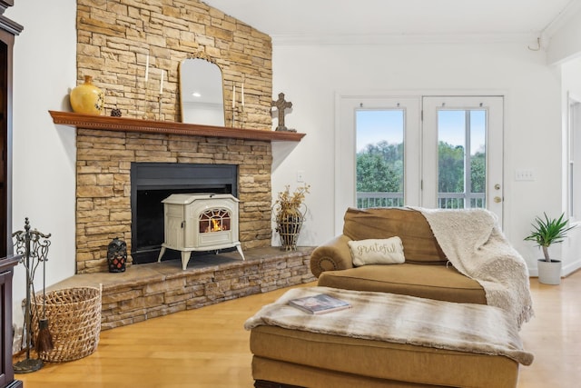 sitting room featuring a wood stove, crown molding, and wood-type flooring