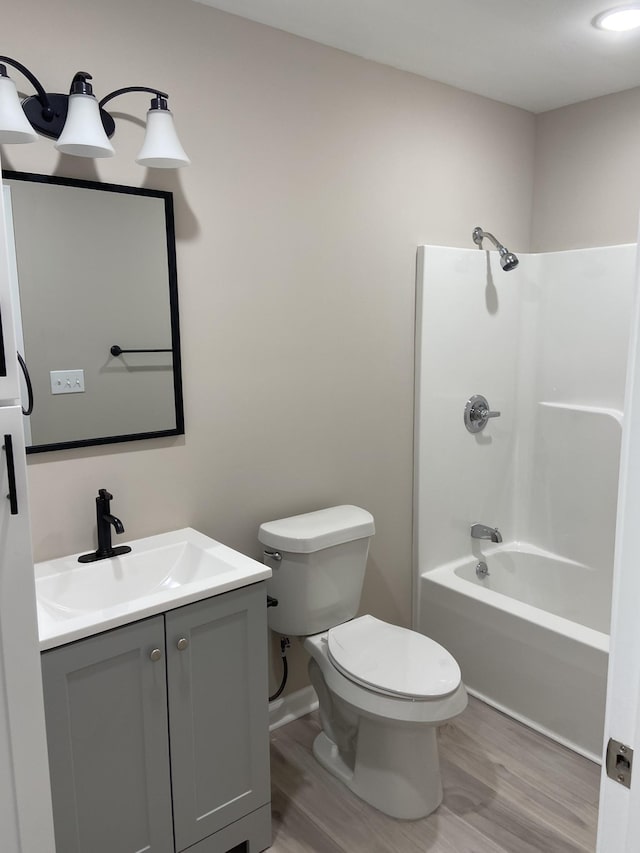 full bathroom with vanity, shower / bathing tub combination, hardwood / wood-style flooring, and toilet