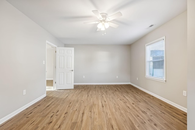 empty room with ceiling fan and light hardwood / wood-style flooring