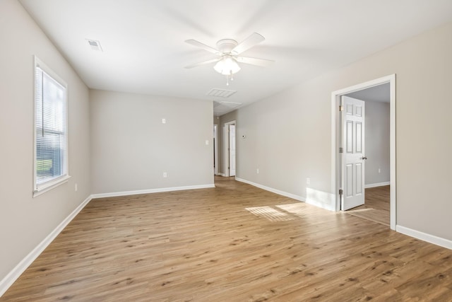 empty room featuring light wood-type flooring, ceiling fan, and a wealth of natural light