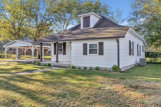 view of front of home featuring a front yard, a carport, a porch, and central AC