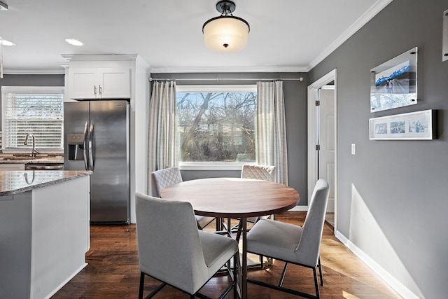 dining room featuring sink, dark hardwood / wood-style floors, and ornamental molding