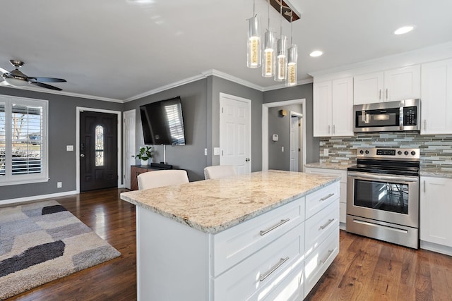 kitchen featuring a center island, appliances with stainless steel finishes, white cabinets, dark hardwood / wood-style flooring, and backsplash