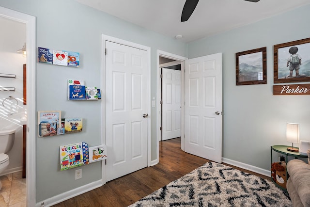 bedroom with ceiling fan, connected bathroom, and dark hardwood / wood-style floors