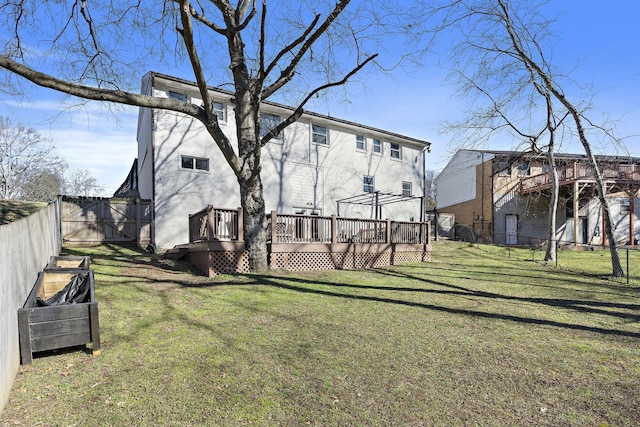 back of house with a wooden deck and a yard