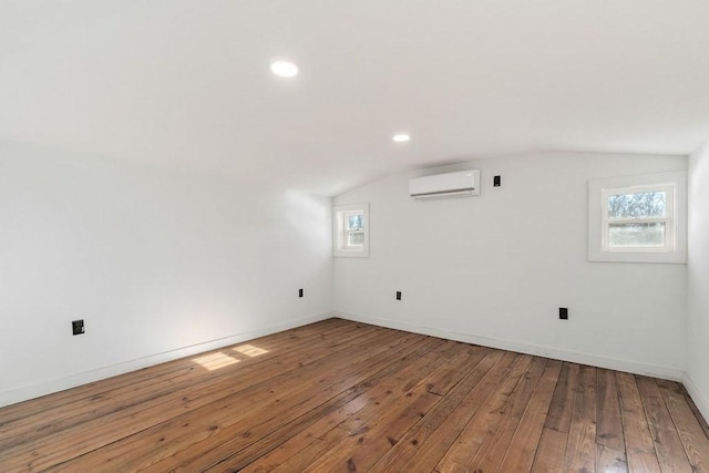 bonus room with wood-type flooring and a wall mounted air conditioner