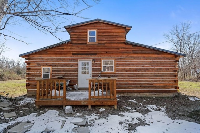 snow covered rear of property featuring a deck