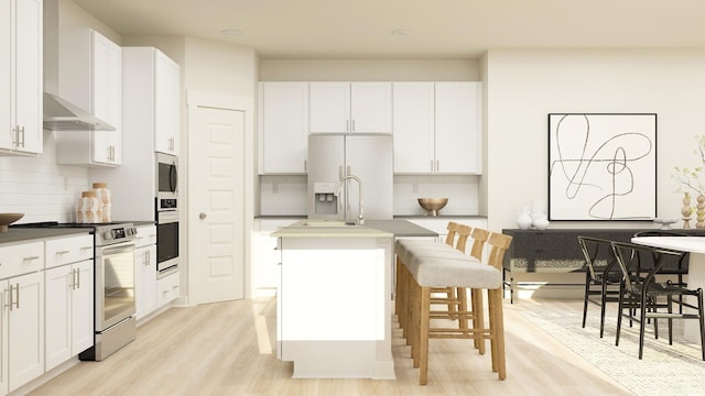 kitchen with a kitchen bar, appliances with stainless steel finishes, white cabinets, and a center island with sink