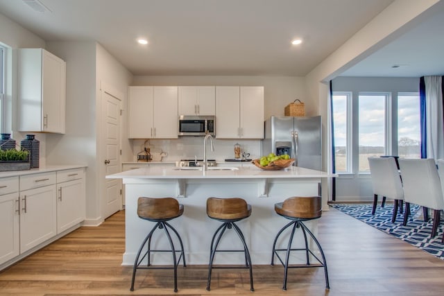 kitchen featuring white cabinetry, a center island with sink, and appliances with stainless steel finishes