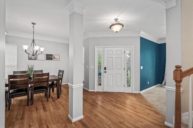 foyer entrance featuring hardwood / wood-style floors, crown molding, and a notable chandelier