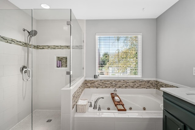 bathroom featuring vanity and independent shower and bath