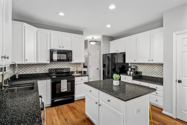 kitchen with white cabinetry, sink, a center island, black appliances, and light hardwood / wood-style flooring