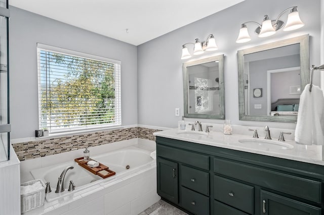 bathroom with vanity and tiled tub