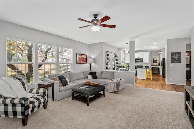 carpeted living room featuring ceiling fan