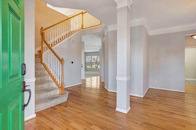 foyer with ornamental molding, light hardwood / wood-style flooring, and ornate columns