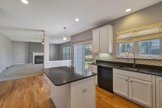 kitchen with sink, a center island, black dishwasher, pendant lighting, and white cabinets