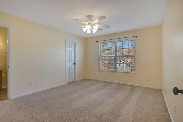 spare room featuring light colored carpet and ceiling fan