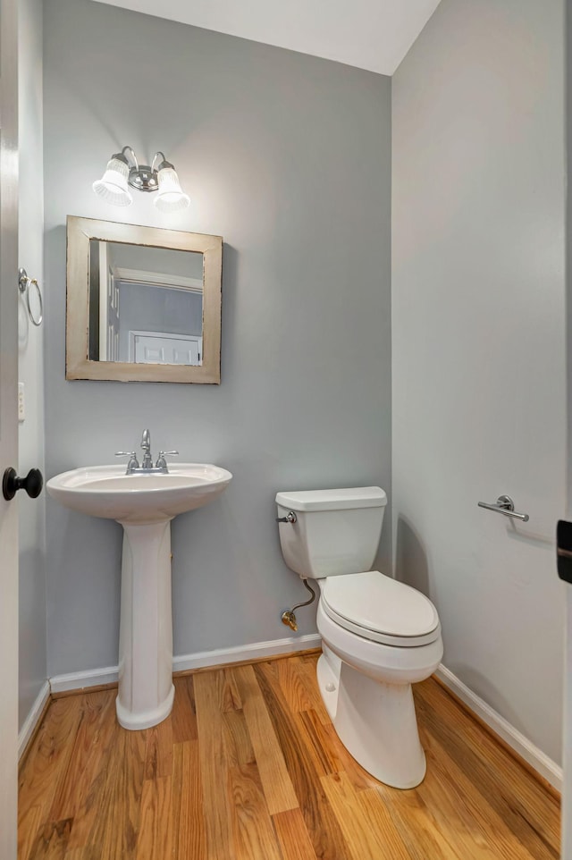 bathroom with hardwood / wood-style floors, sink, and toilet