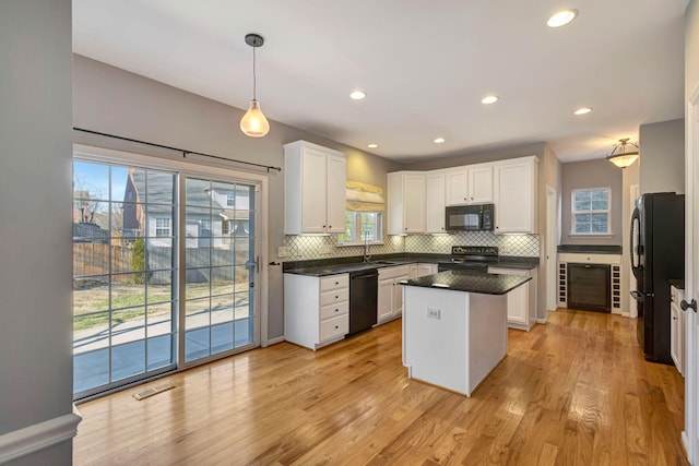 kitchen featuring sink, black appliances, hanging light fixtures, a kitchen island, and white cabinets