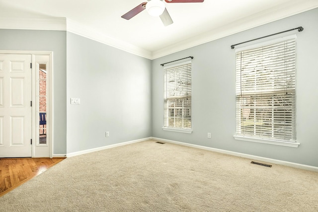 unfurnished room featuring carpet flooring, visible vents, crown molding, and baseboards