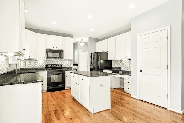 kitchen with black appliances, a kitchen island, and white cabinets