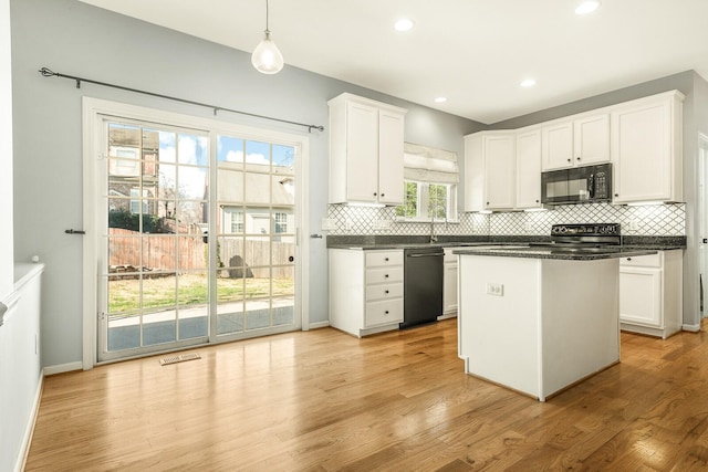 kitchen with dark countertops, pendant lighting, white cabinetry, and black appliances