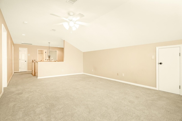 unfurnished living room with lofted ceiling, baseboards, a ceiling fan, and light colored carpet