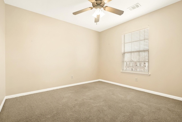 carpeted spare room with a ceiling fan, visible vents, and baseboards