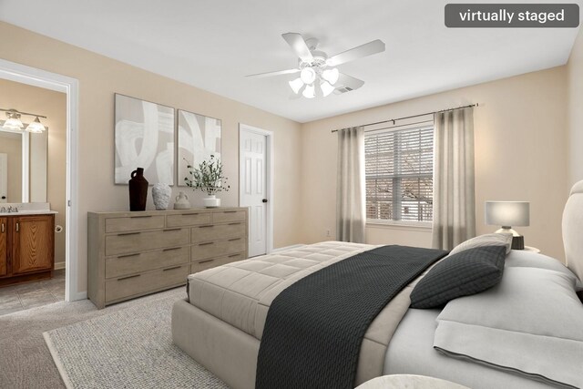 bedroom featuring baseboards, visible vents, a ceiling fan, light colored carpet, and ensuite bath