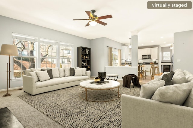 carpeted living room featuring beverage cooler, baseboards, a ceiling fan, and recessed lighting