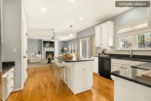 kitchen featuring black dishwasher, hanging light fixtures, open floor plan, white cabinets, and a kitchen island