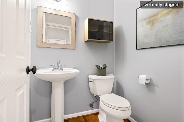 bathroom featuring wood finished floors, toilet, and baseboards