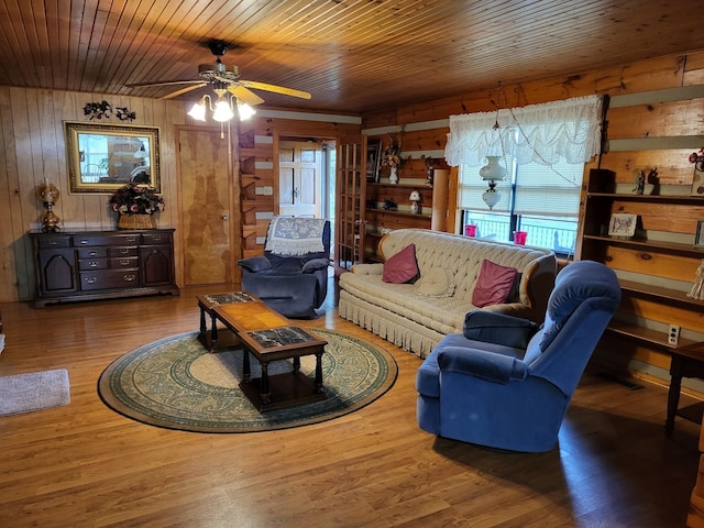 living room featuring hardwood / wood-style floors, wooden walls, ceiling fan, and wood ceiling