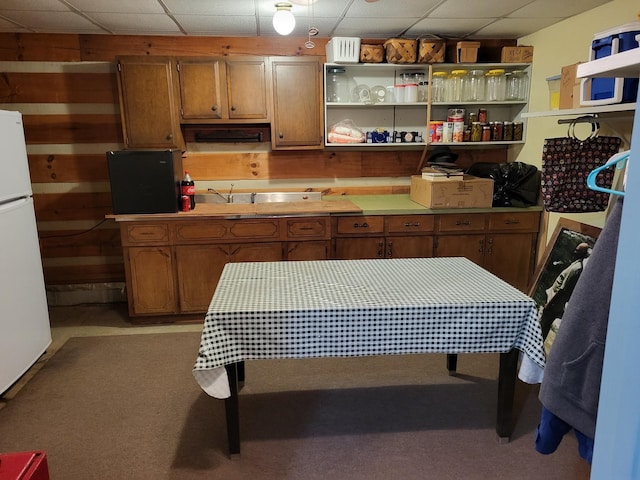 kitchen featuring light colored carpet and white fridge