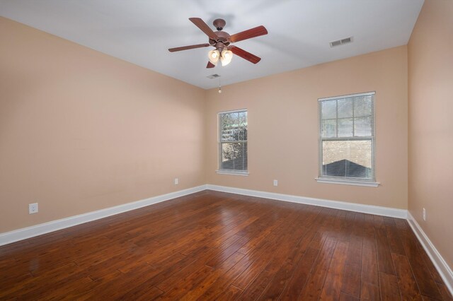 spare room featuring ceiling fan and dark wood-type flooring