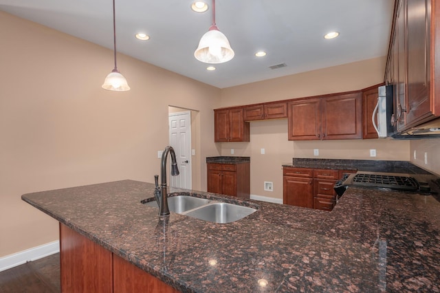 kitchen with kitchen peninsula, pendant lighting, sink, dark wood-type flooring, and stove