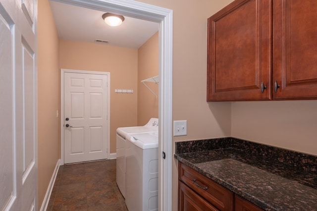 clothes washing area featuring washing machine and clothes dryer and cabinets