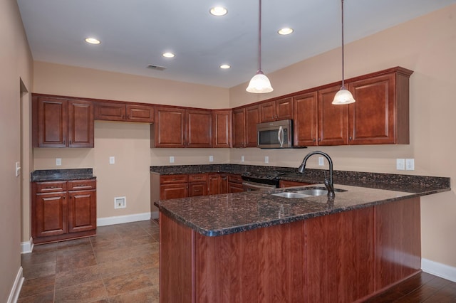 kitchen with sink, dark stone countertops, kitchen peninsula, and pendant lighting