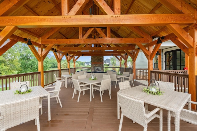 wooden deck featuring an outdoor stone fireplace