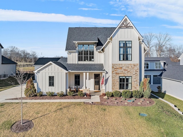 modern farmhouse with a front yard and a porch