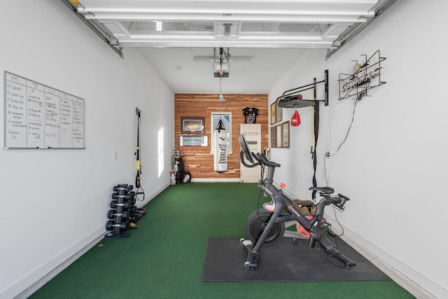 exercise room featuring wood walls and carpet