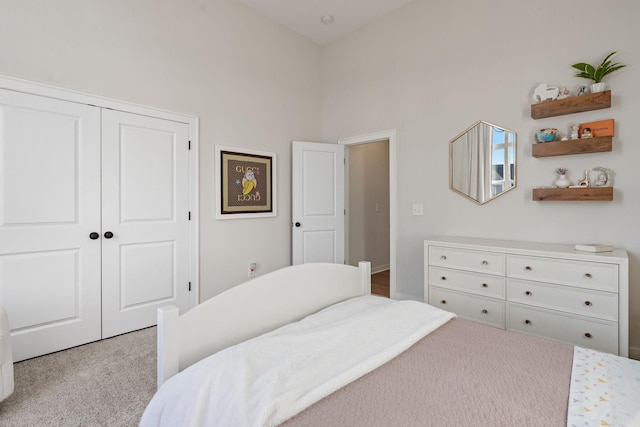 carpeted bedroom featuring a high ceiling and a closet