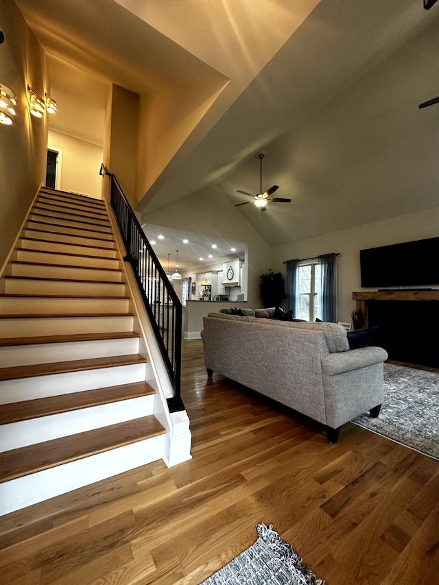 living room with ceiling fan, lofted ceiling, and wood-type flooring