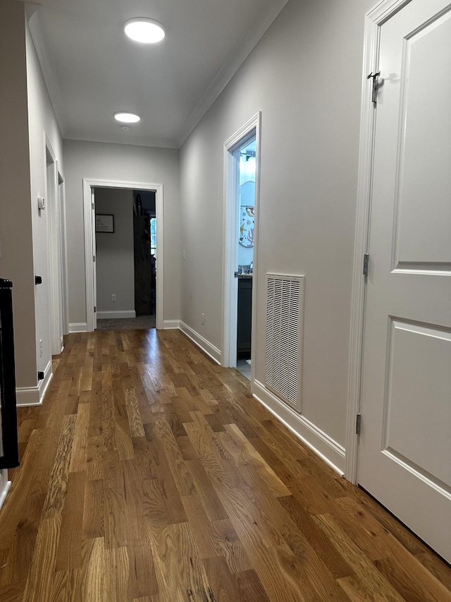 corridor featuring crown molding and hardwood / wood-style flooring