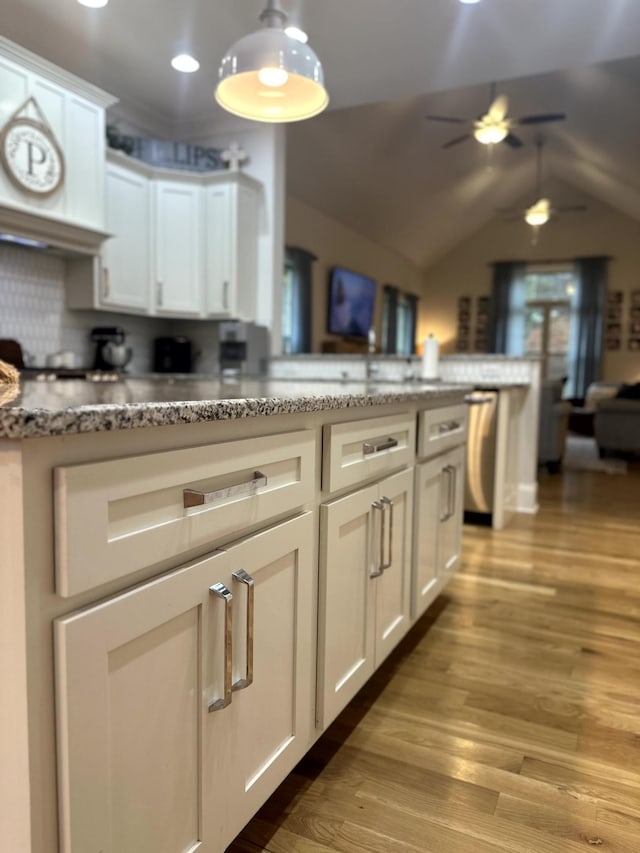 kitchen featuring white cabinets, tasteful backsplash, lofted ceiling, and light hardwood / wood-style floors