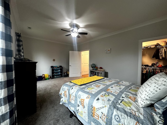 carpeted bedroom with a closet, ceiling fan, a spacious closet, and ornamental molding