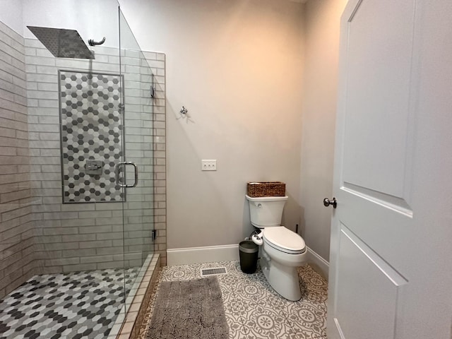 bathroom with toilet, an enclosed shower, and tile patterned flooring